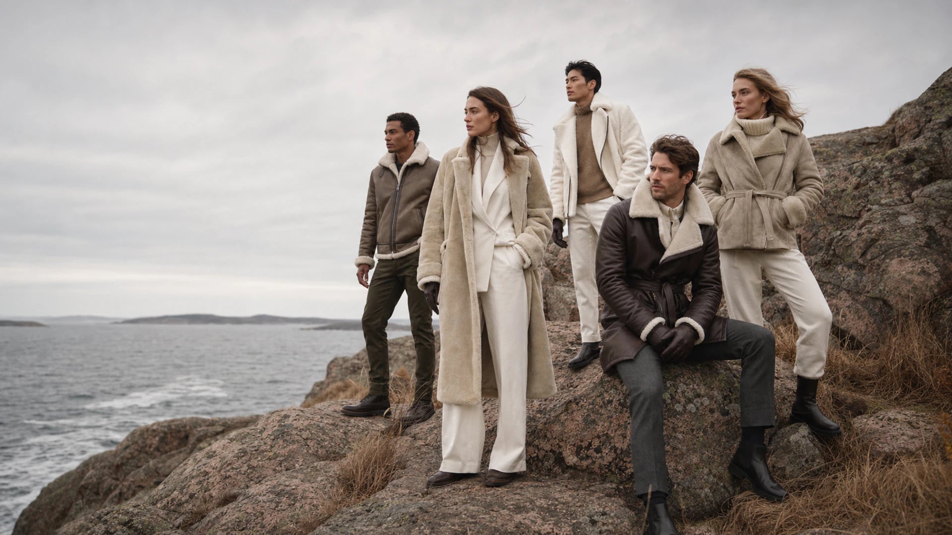 ORLAVEN men and women wearing leather and shearling outerwear on a rugged coast