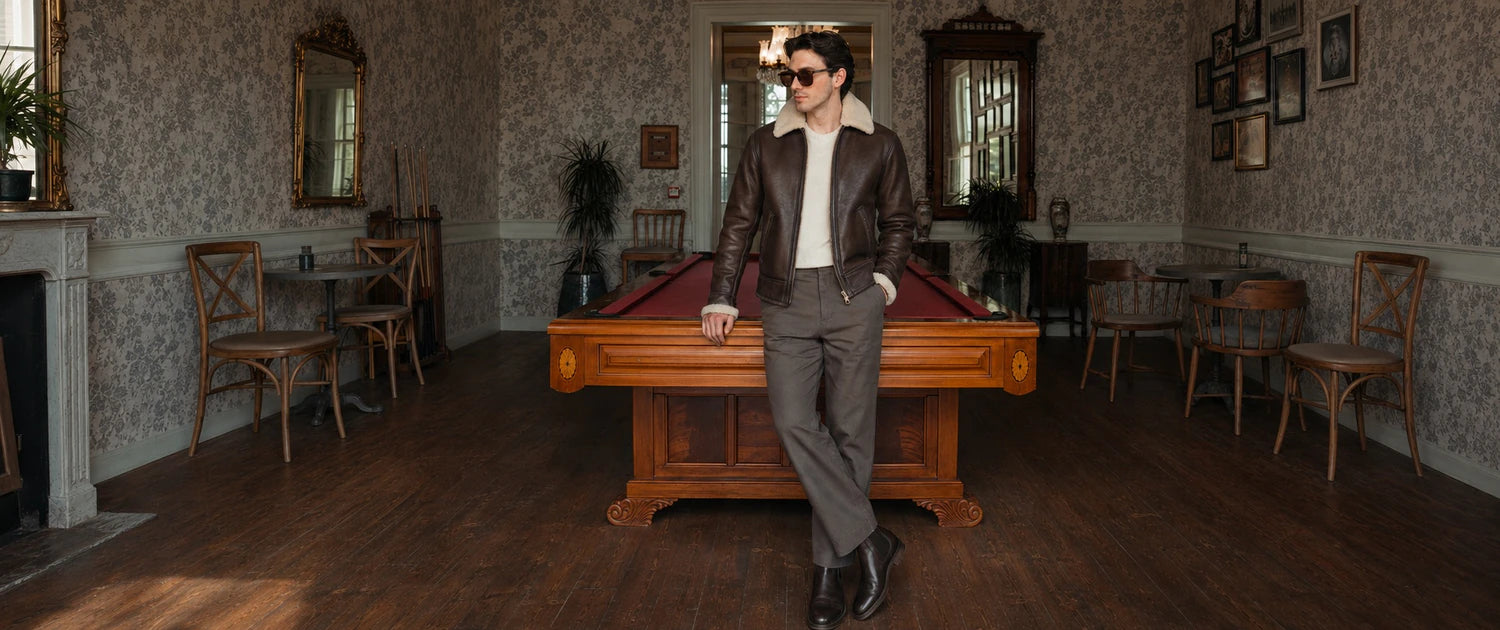 Man wearing a brown ORLAVEN shearling leather jacket beside a billiards table
