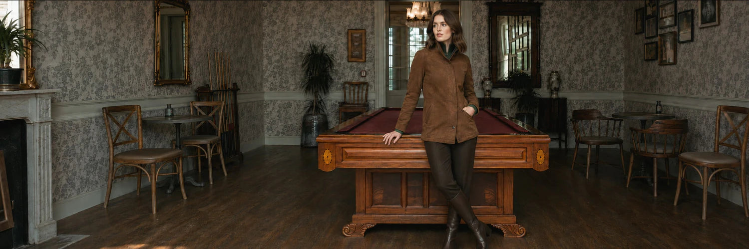 Woman wearing a brown ORLAVEN suede jacket beside a billiards table
